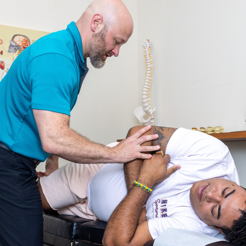 Dr Eric Chludzinski giving his patient chiropractor treatment